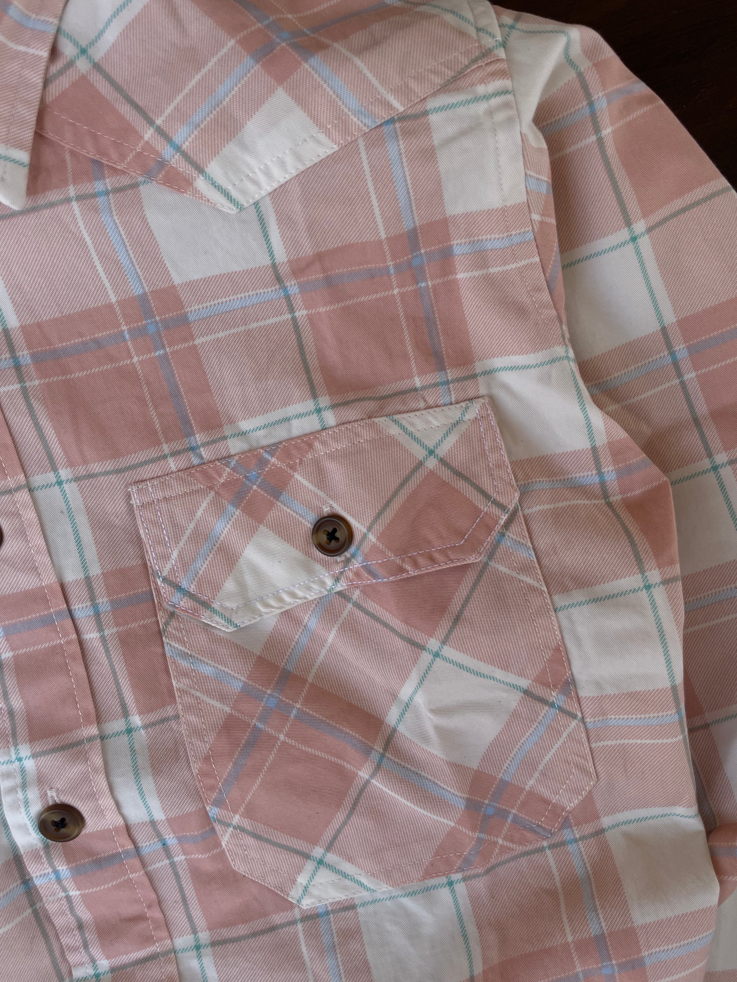 Peach plaid western shirt detail with button front and flap chest pockets