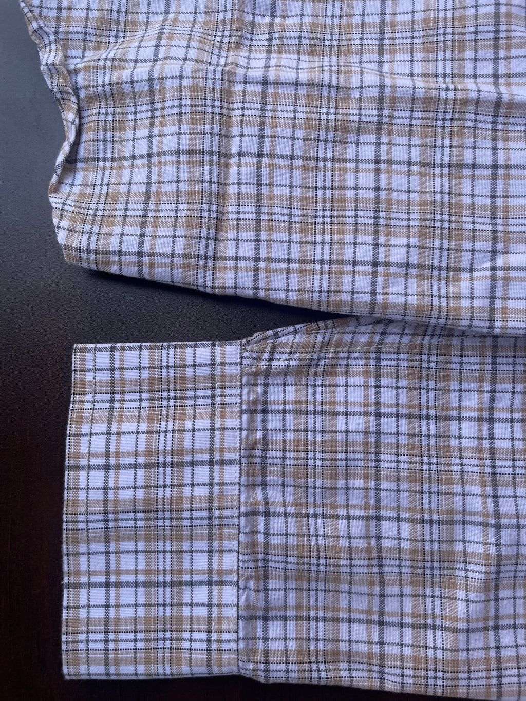 Lower front of small-check shirt with buttoned placket and pocket flap detail