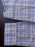 Lower front of small-check shirt with buttoned placket and pocket flap detail