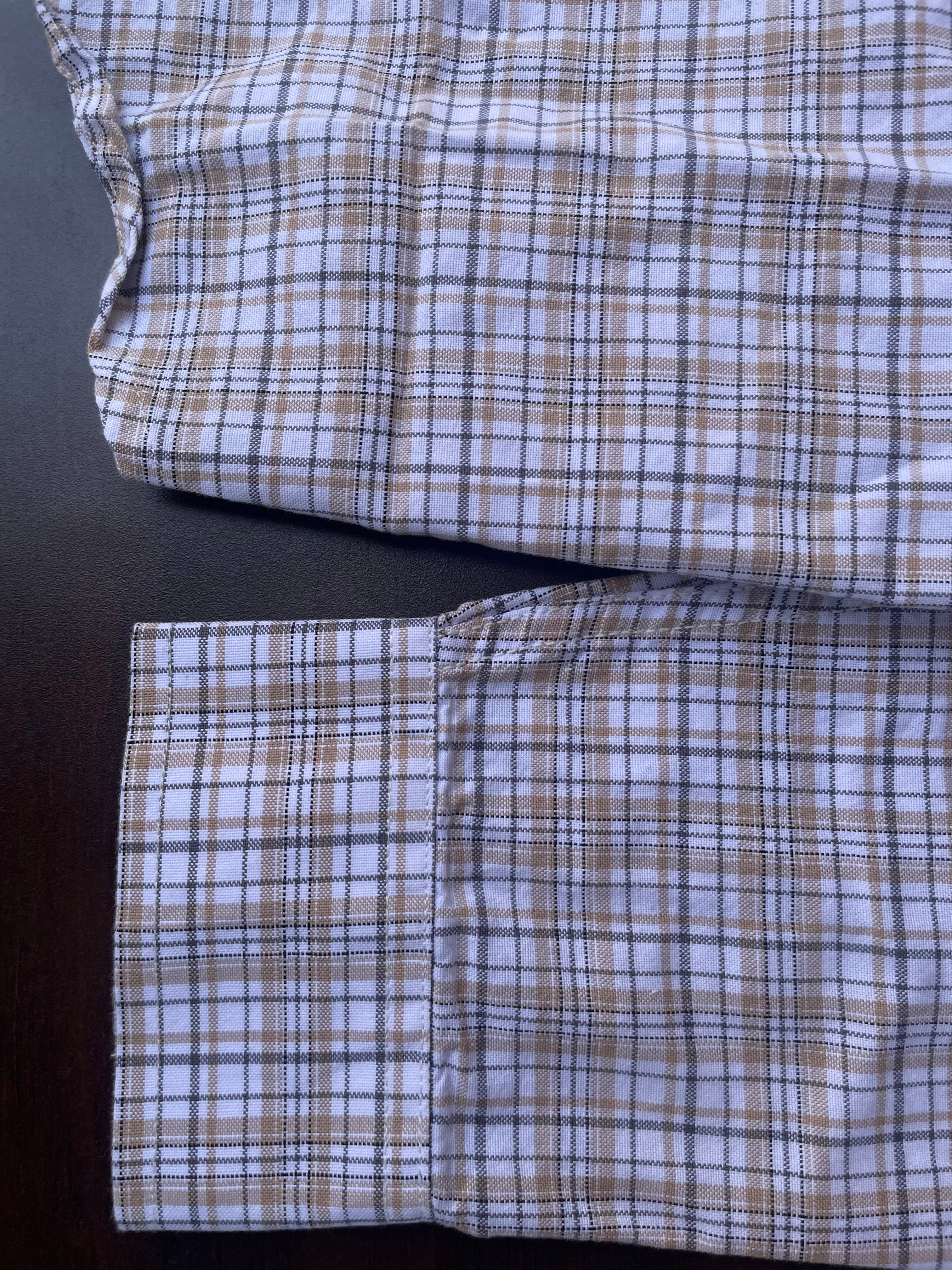 Lower front of small-check shirt with buttoned placket and pocket flap detail