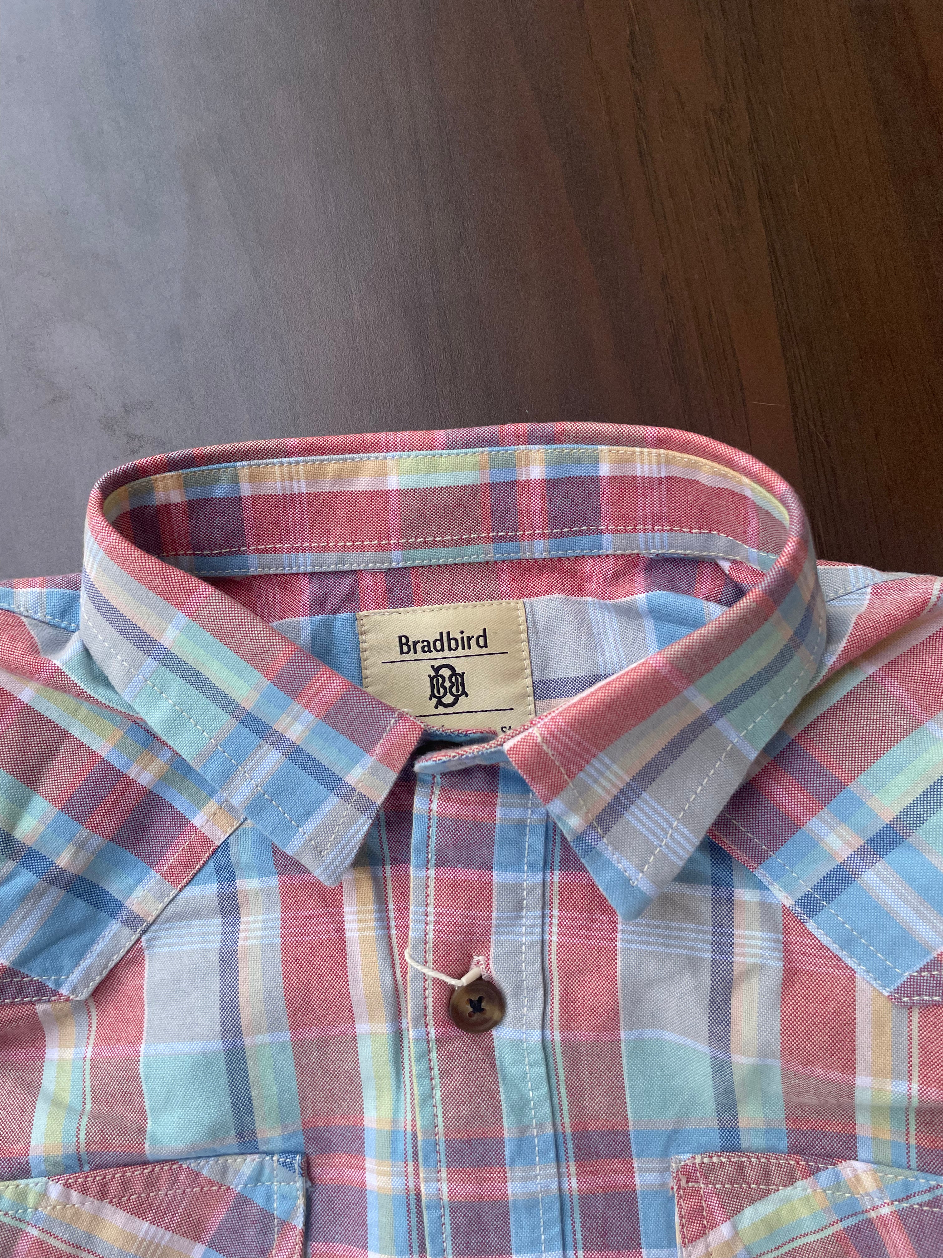 Collar and placket of red, blue, and green plaid casual shirt with brown button