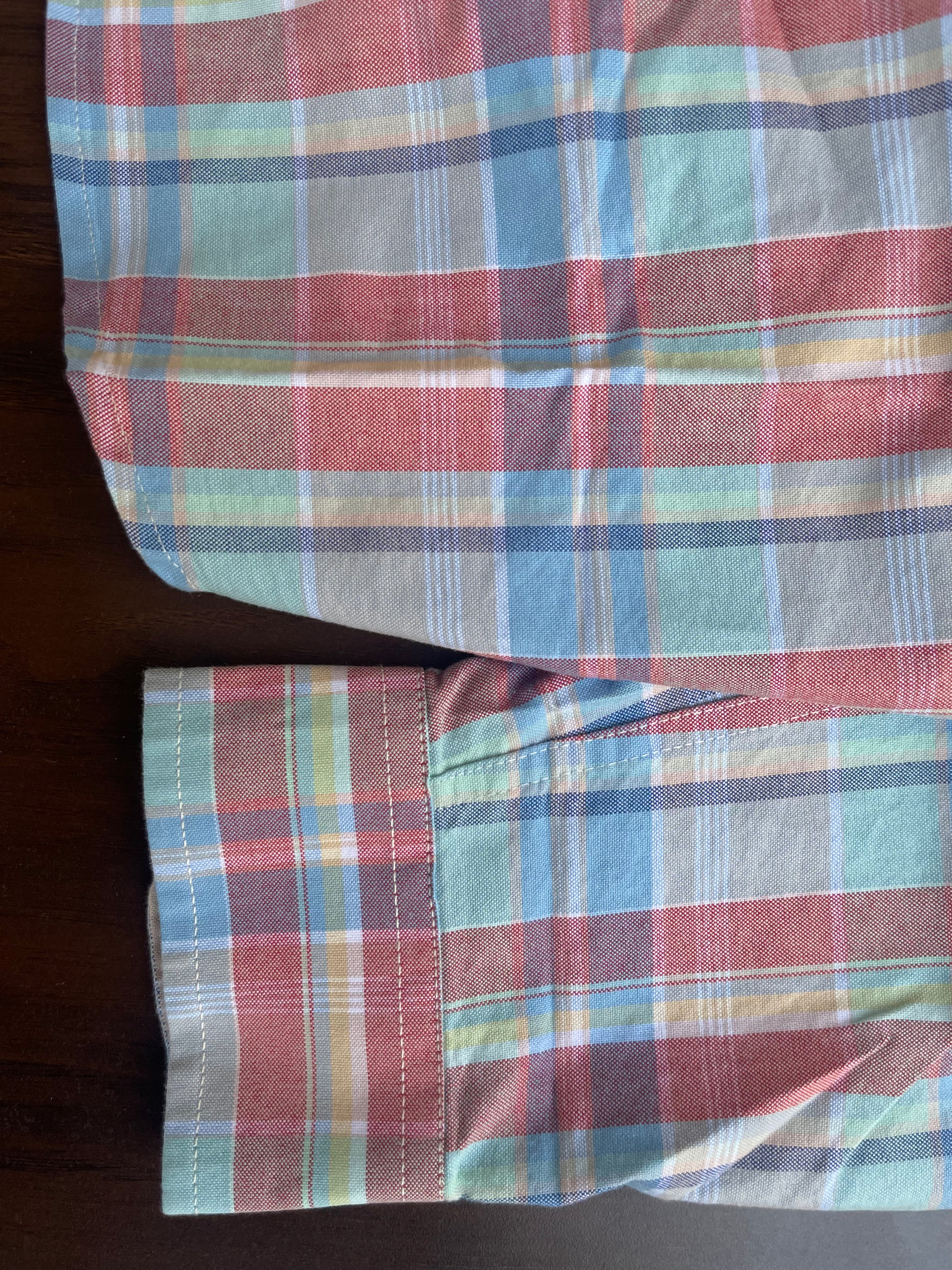 Red, blue, and green check casual shirt cuff detail with buttoned sleeve