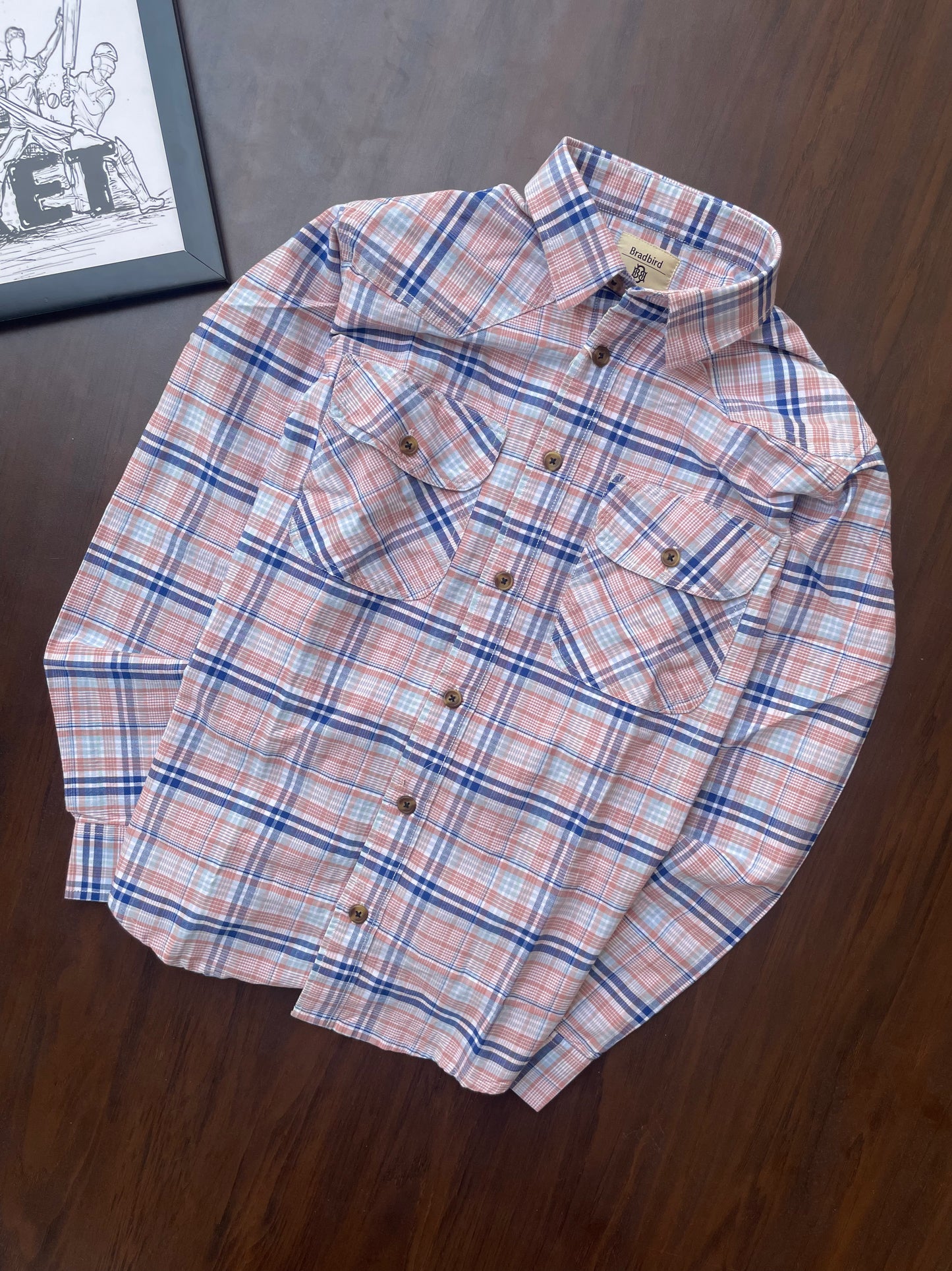 Folded pink and blue plaid cotton shirt, button front and point collar