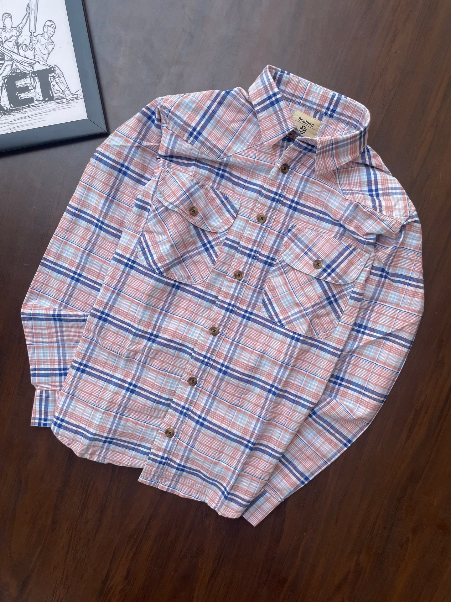 Folded pink and blue plaid cotton shirt, button front and point collar