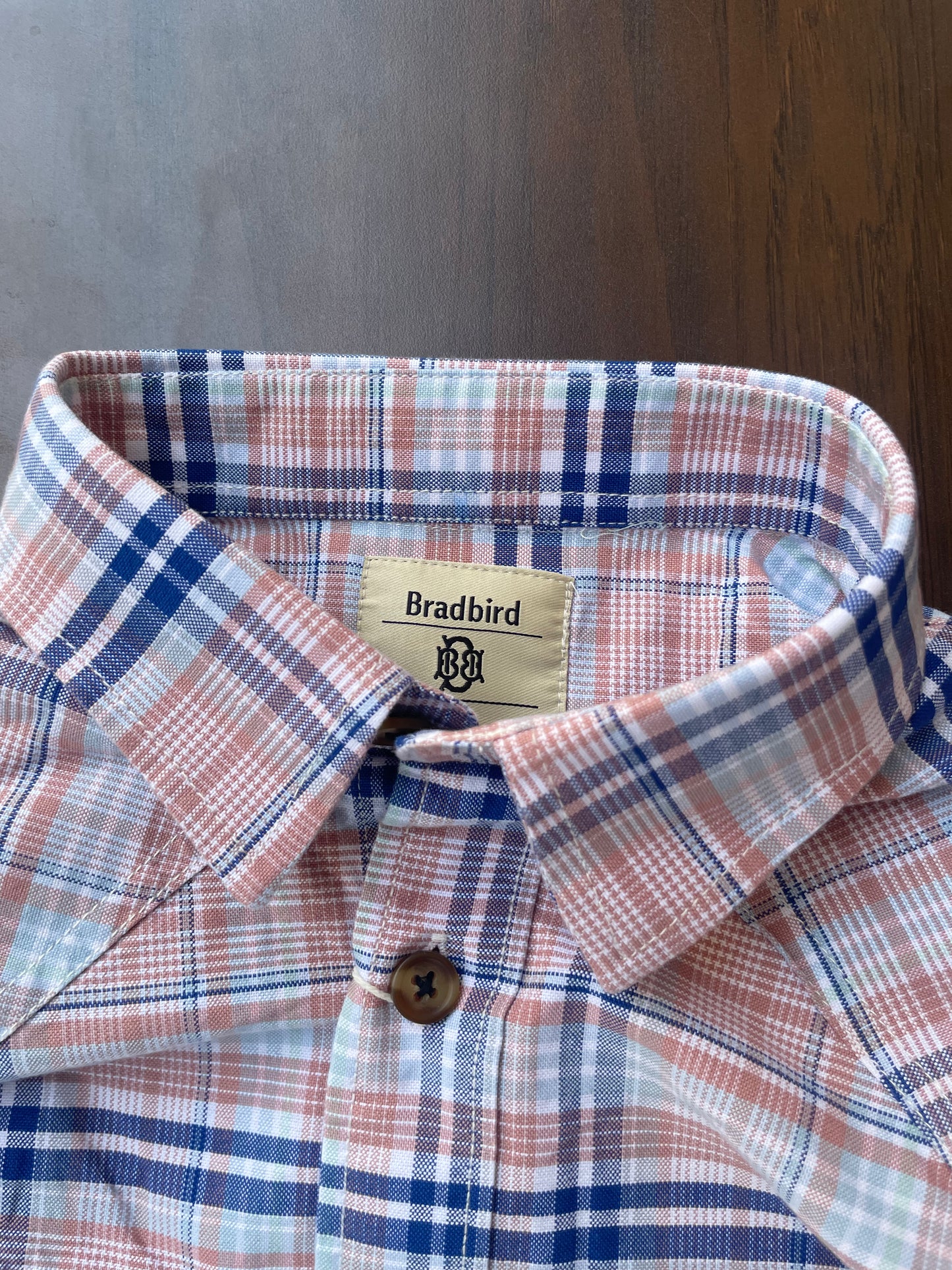 Pink and blue plaid shirt collar and button detail with inner neck label