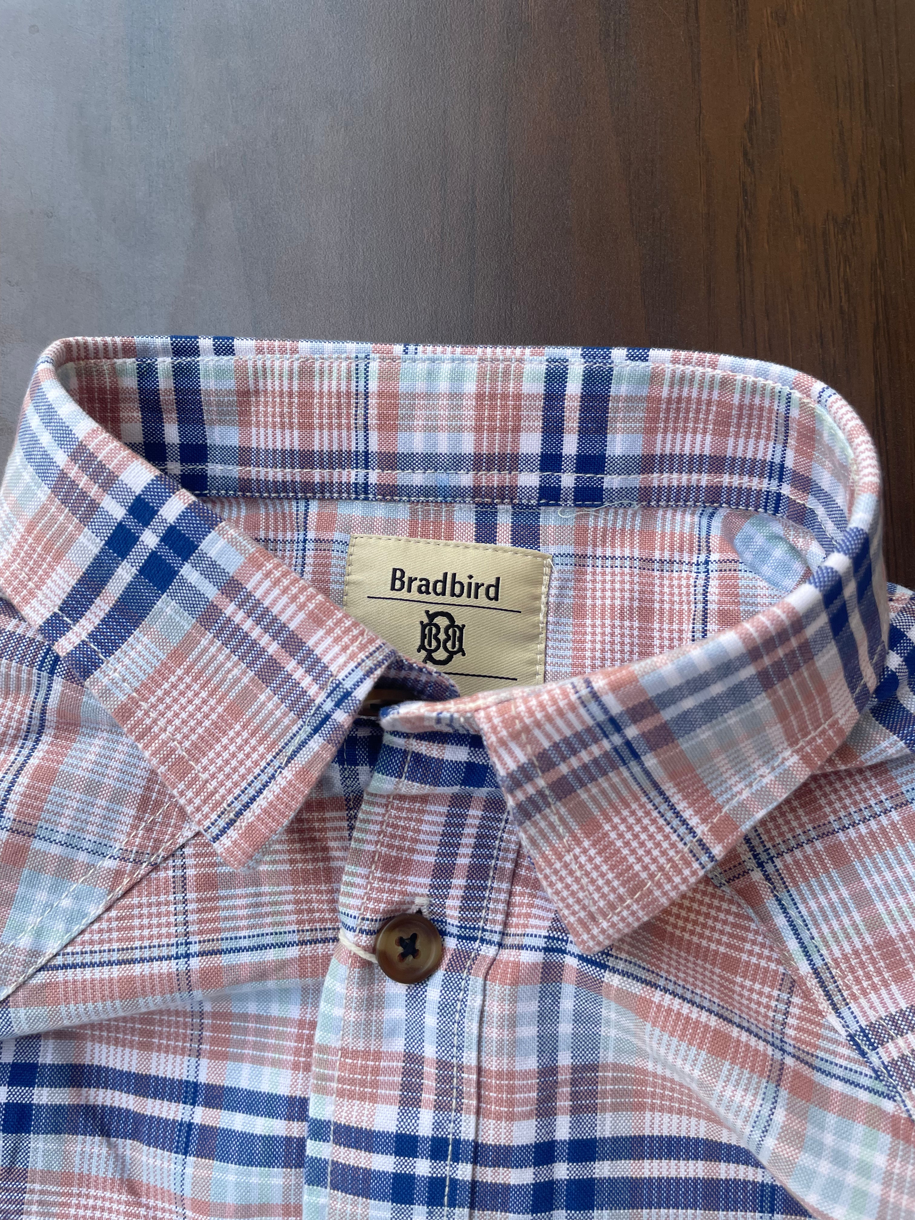 Pink and blue plaid shirt collar and button detail with inner neck label