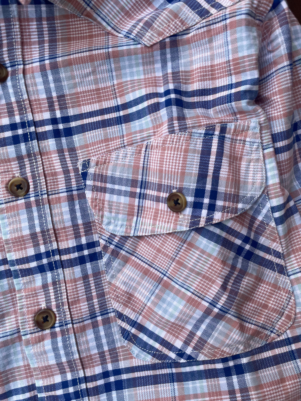 Pink and blue plaid shirt with chest pockets and buttoned front placket