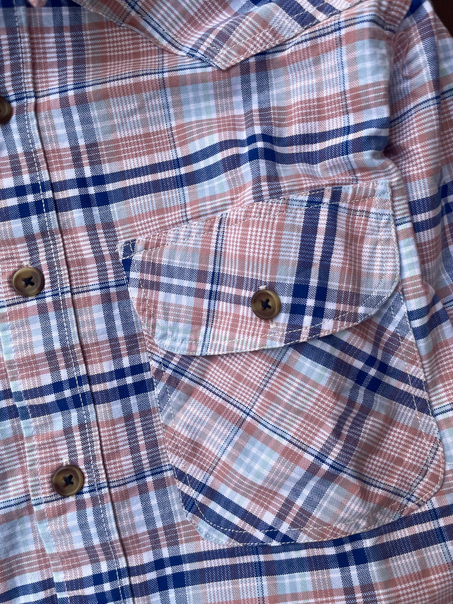 Pink and blue plaid shirt with chest pockets and buttoned front placket