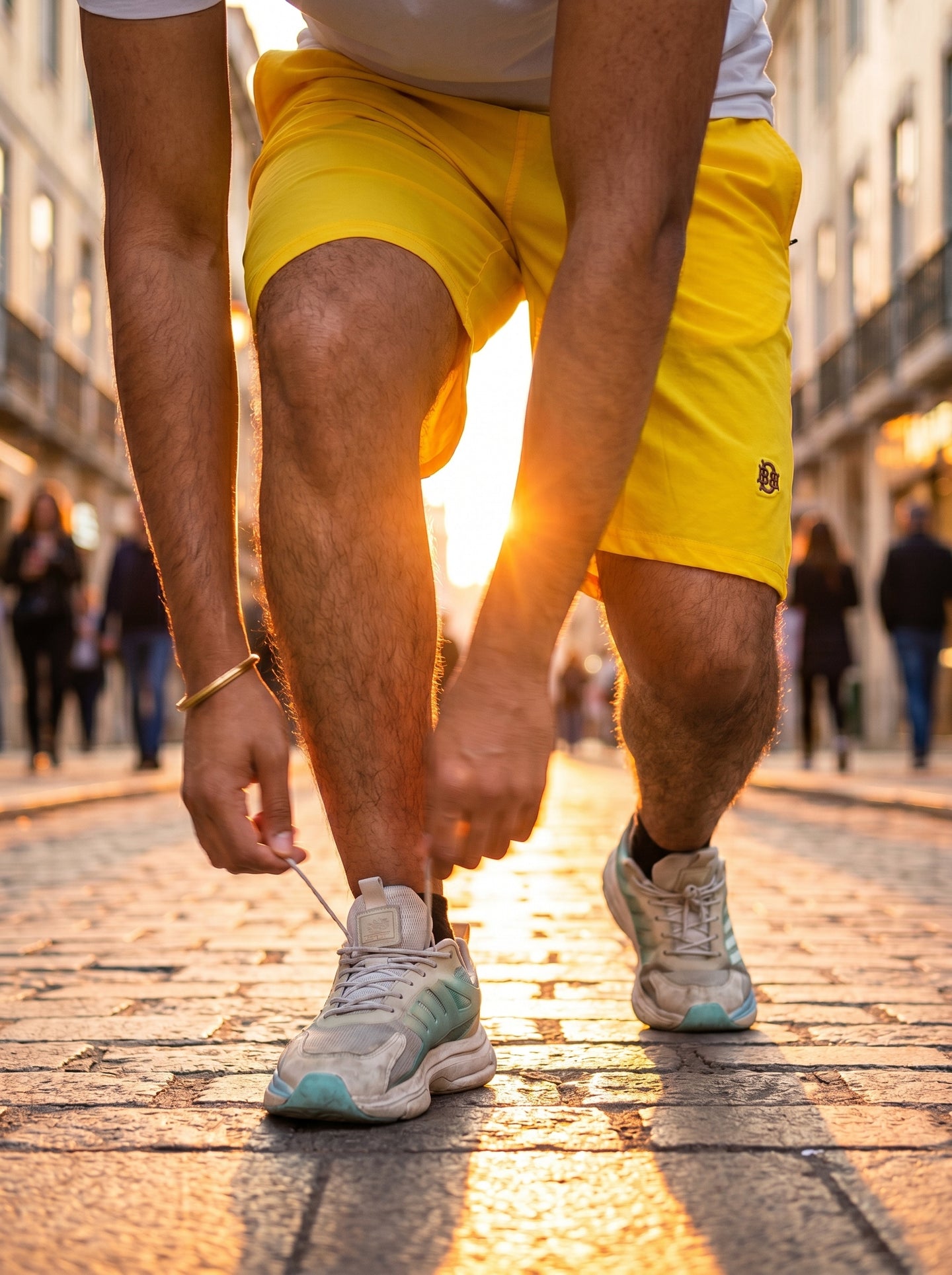 Bright yellow quick-dry shorts, elastic waistband view and front pocket seam, side logo