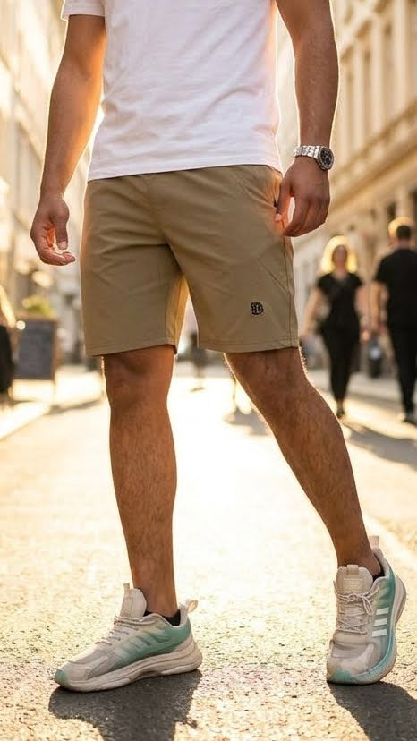 Khaki casual shorts, knee-length with side pockets and small logo patch