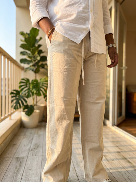 Cream linen trousers with adjustable drawstring waist and roomy straight legs