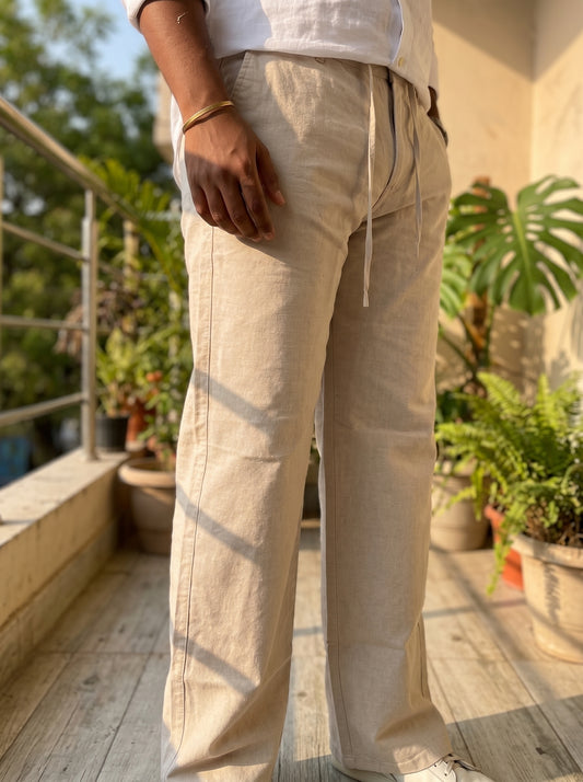Natural beige linen pants side view, drawstring waist and roomy straight fit