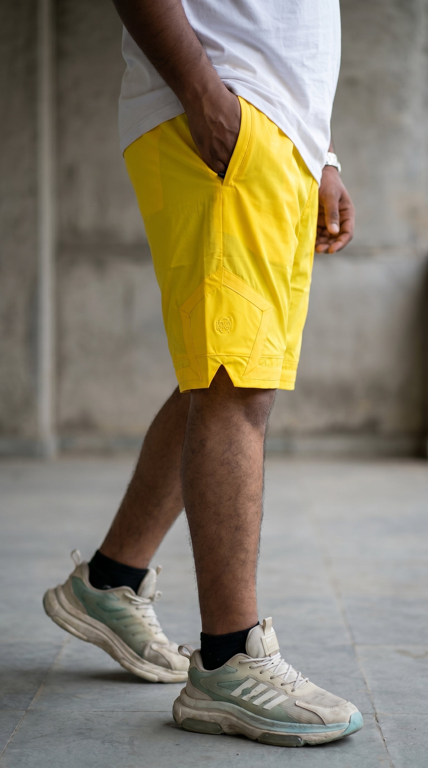 Yellow cargo shorts with cargo pocket panel and subtle embroidery on thigh