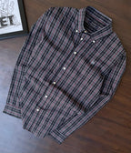 Folded dark plaid button-up shirt, red and white check pattern, front buttons and chest yoke