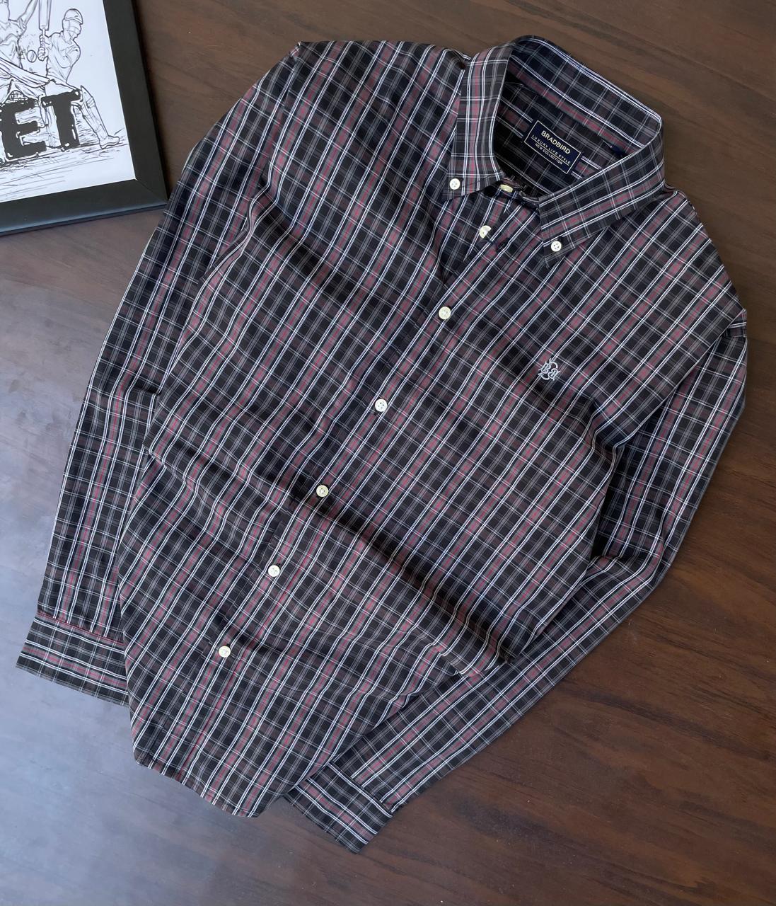 Folded dark plaid button-up shirt, red and white check pattern, front buttons and chest yoke