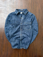 Mid-wash denim shirt laid flat, button front and single chest pocket.
