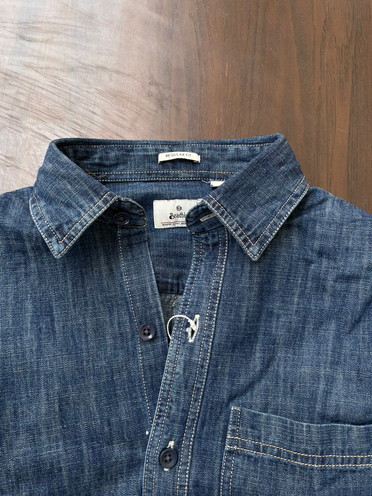 Mid-wash denim shirt neckline with brand label, button placket and chest pocket.