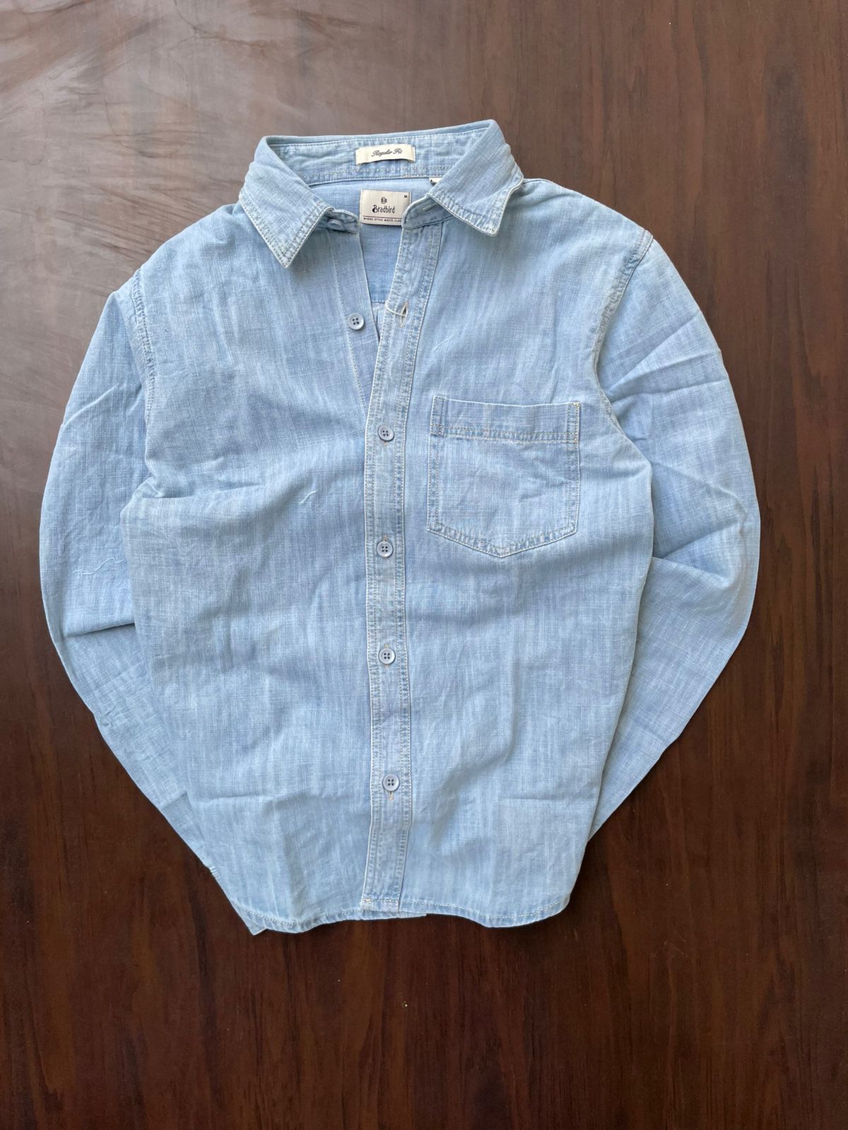 Ice blue textured denim shirt on hanger, button front and single chest pocket