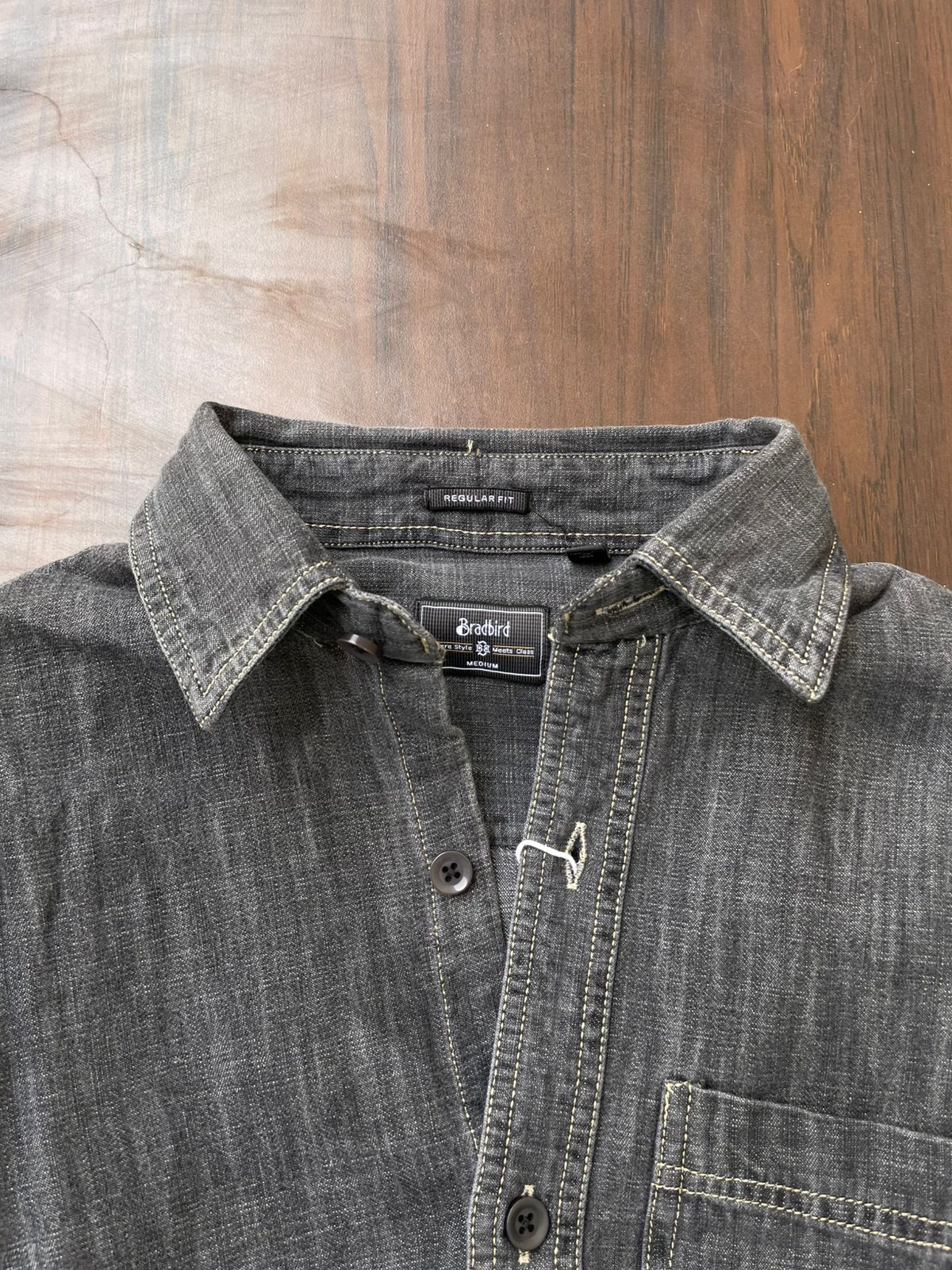 Light grey acid-wash denim shirt neckline with inner label and button placket