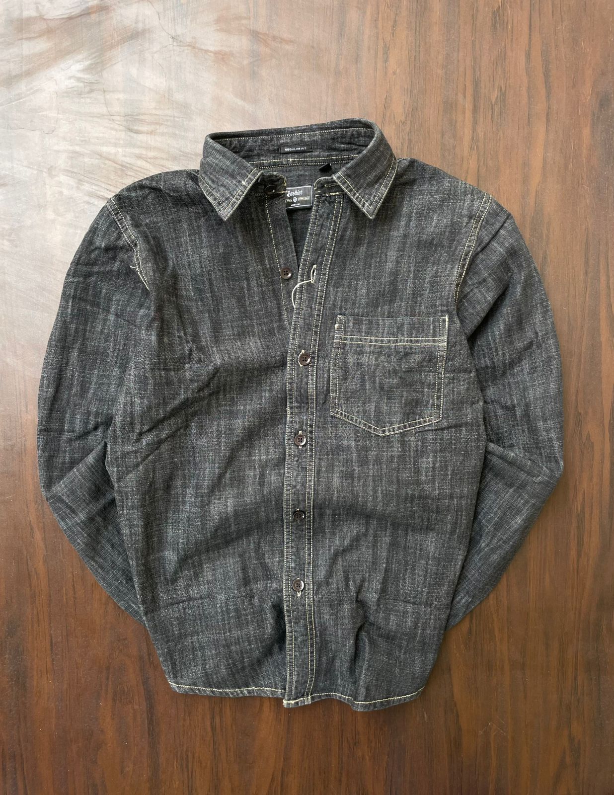 Deep grey denim shirt laid flat; button front, pointed collar, chest pocket, contrast stitching