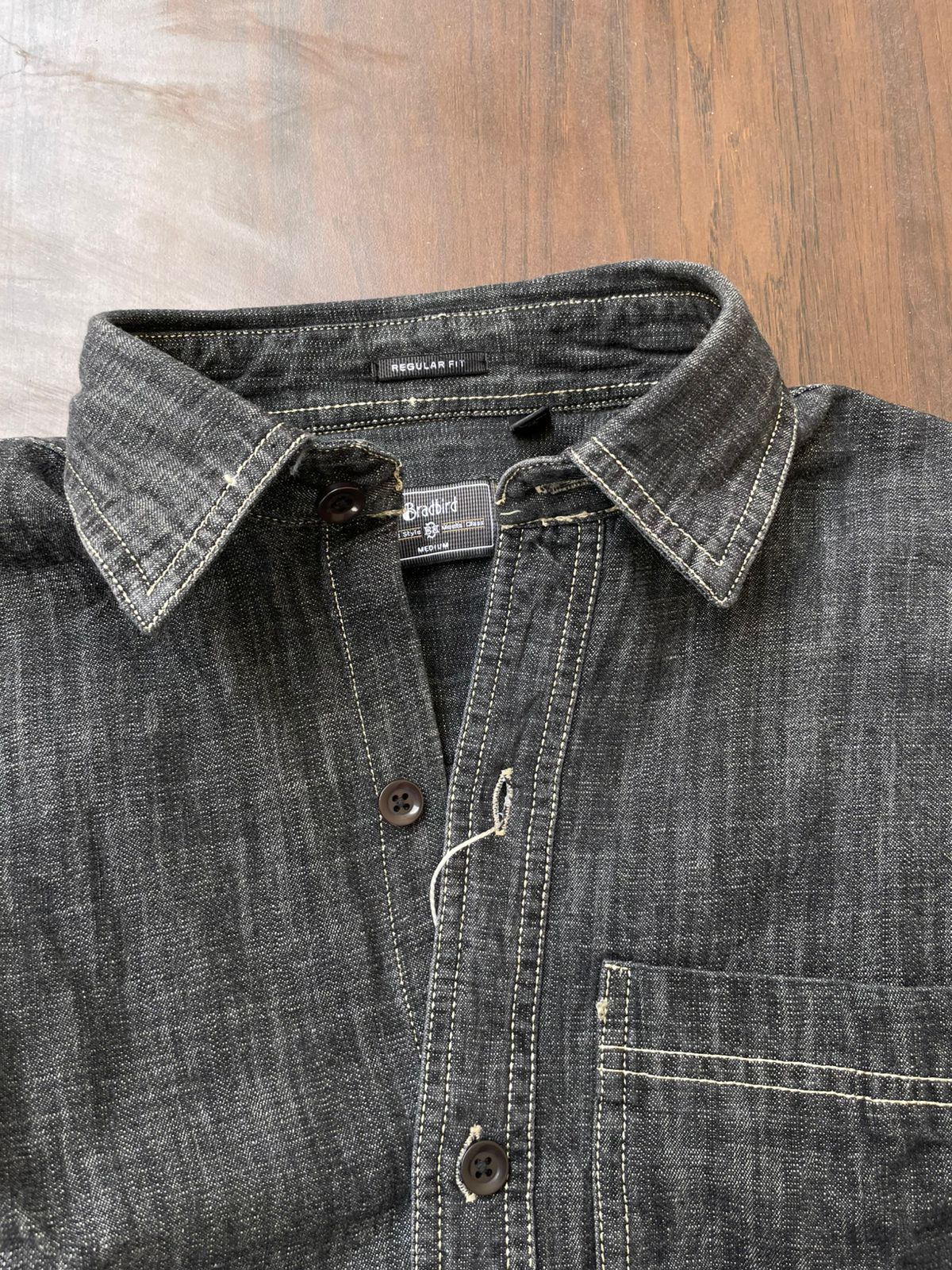 Deep grey denim shirt close-up of collar and placket; contrast stitching and button detail