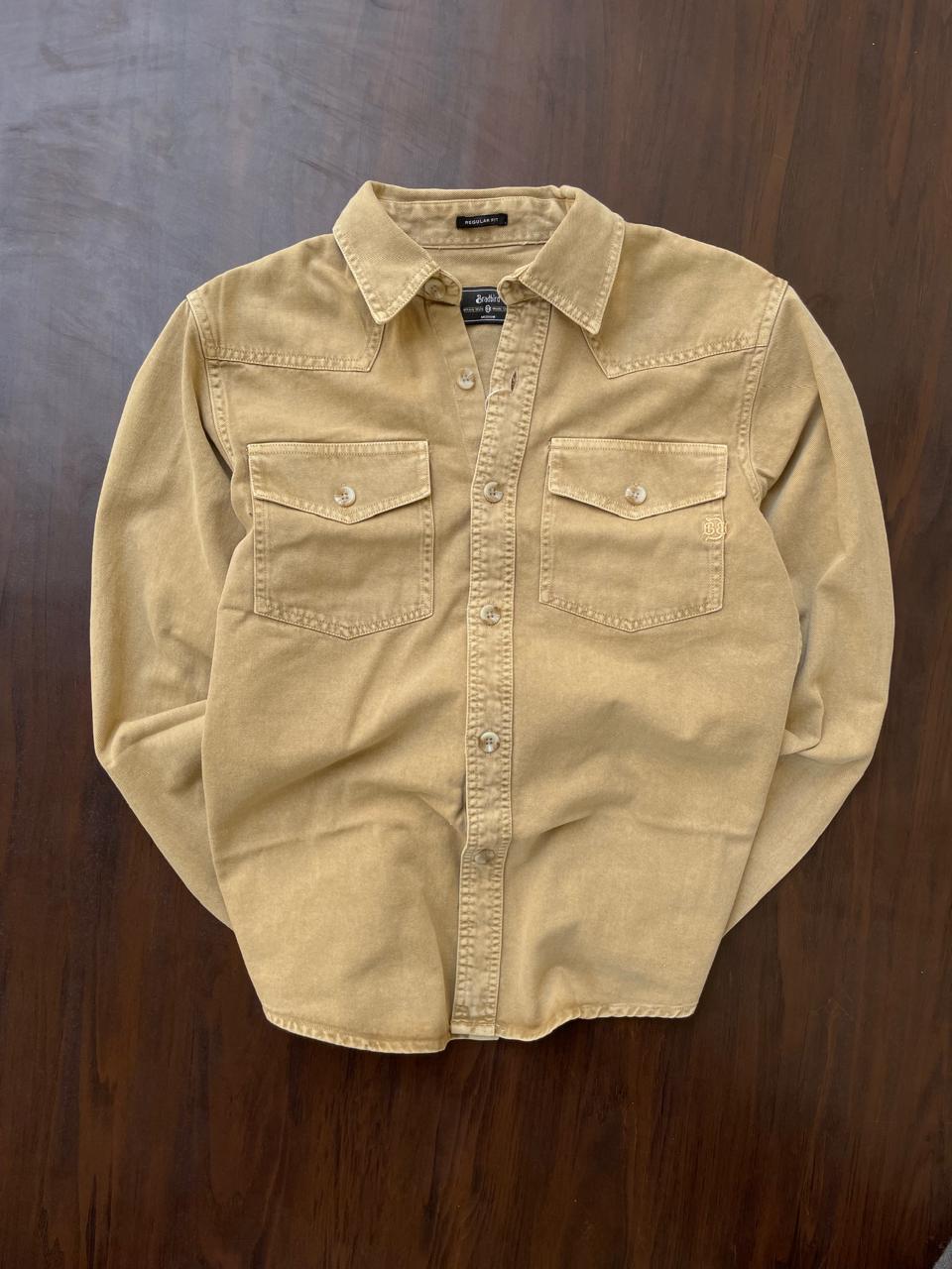 Tan beige denim western shirt laid flat, with pointed collar and two chest flap pockets