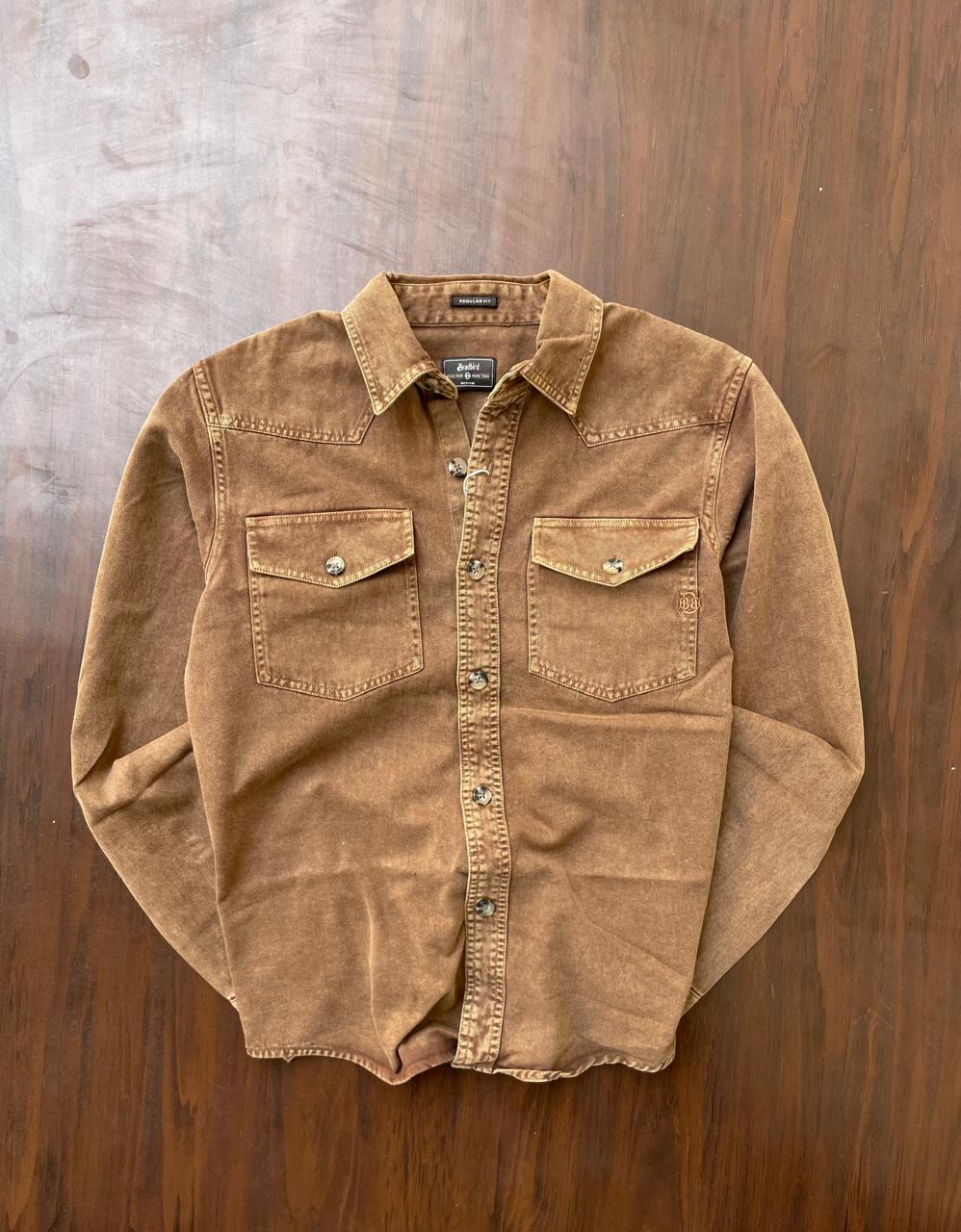 Tan-brown denim western shirt laid flat with pointed collar and snap front.