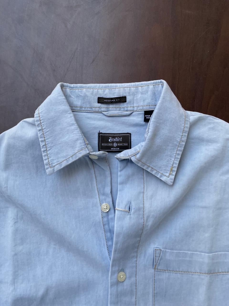Light blue denim shirt collar and neckline view with brand labels