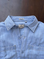 Men's light-wash denim shirt collar close-up with regular fit label and button front