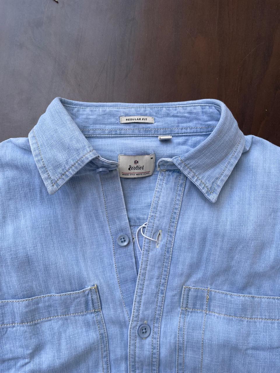 Men's light-wash denim shirt collar close-up with regular fit label and button front