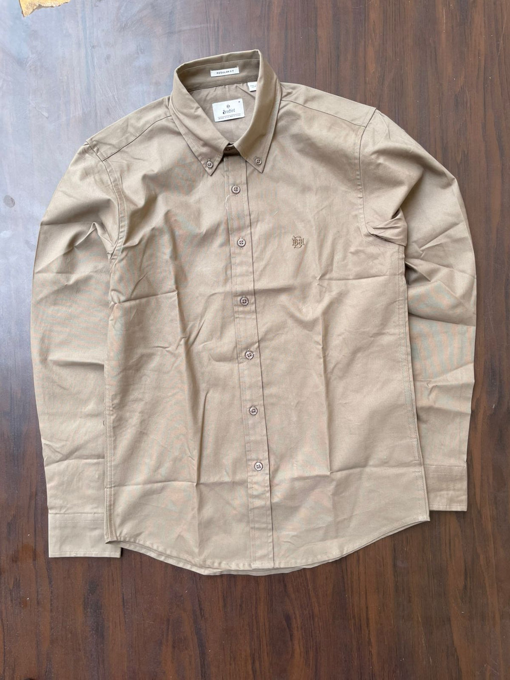 Khaki textured oxford button-up shirt on hanger, front view with buttons