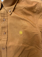 Close-up of mustard oxford shirt buttons and contrast monogram on chest