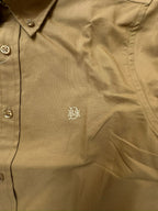 Close-up of tan khaki oxford shirt chest with tonal monogram and buttons