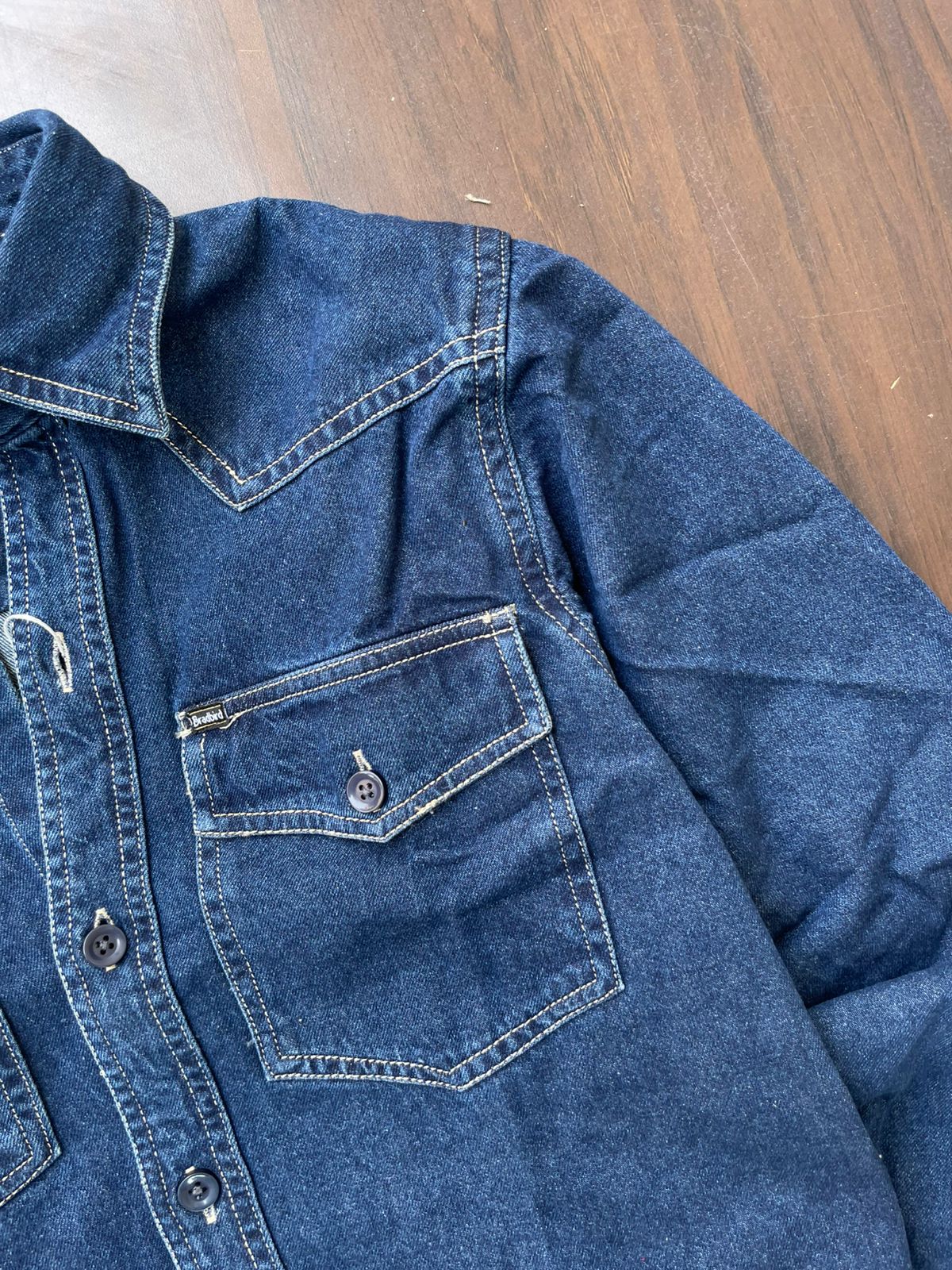 Blue denim western-style shirt sleeve and chest pocket with button detail