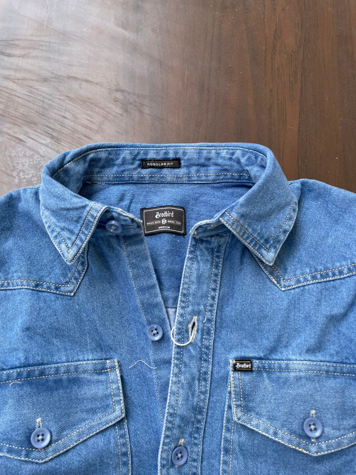 Medium wash denim western shirt close-up: point collar, button front, flap pockets