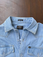 Light wash denim over-shirt close-up of neck label and snap-front placket