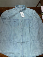 Light blue denim button-up shirt with two front chest pockets and collar