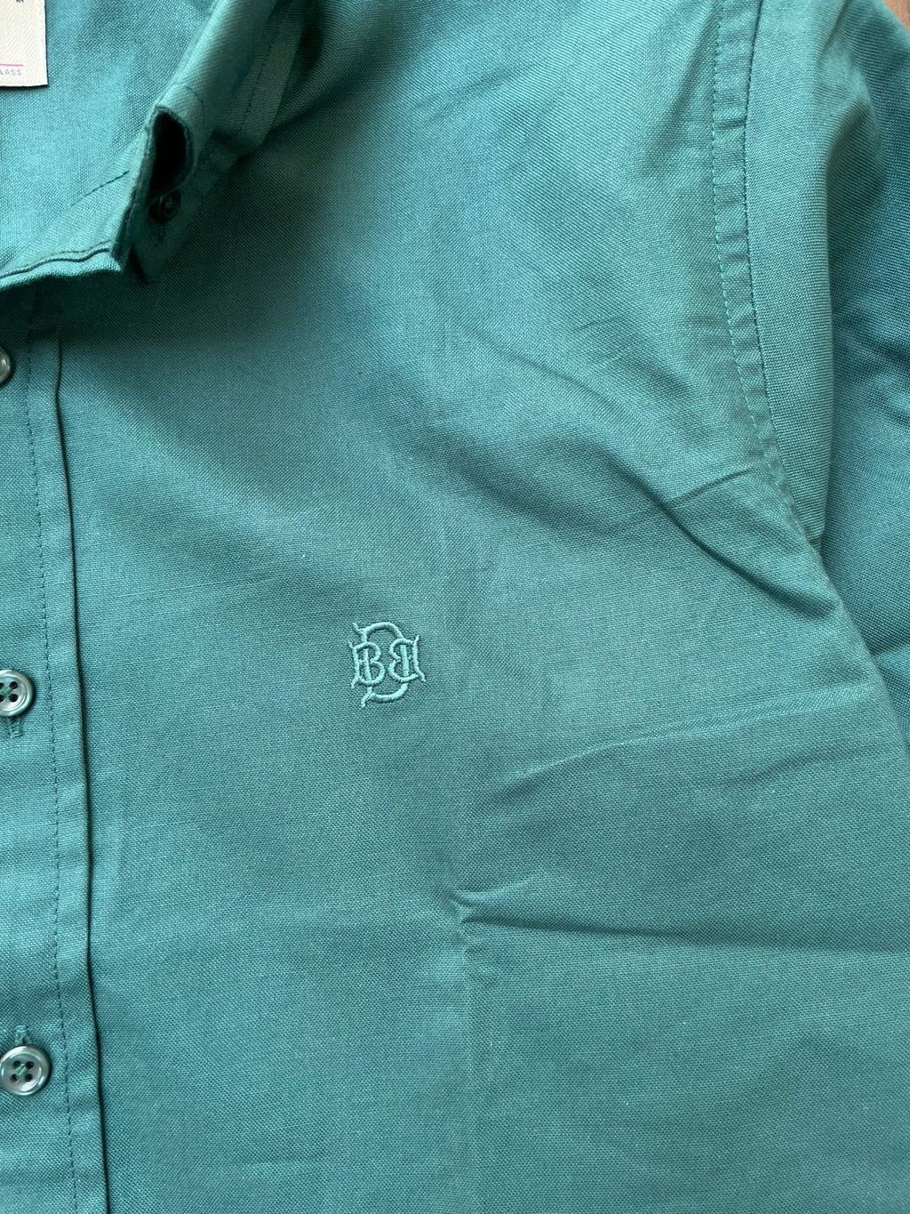 Green textured oxford shirt closeup of tonal monogram on chest