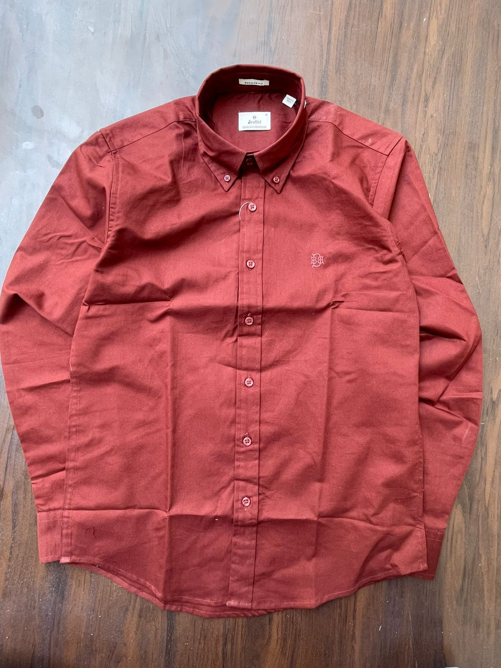 Maroon textured oxford button-up shirt laid flat, chest button placket and collar