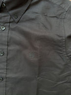 Black shirt close-up showing tonal monogram and button placket