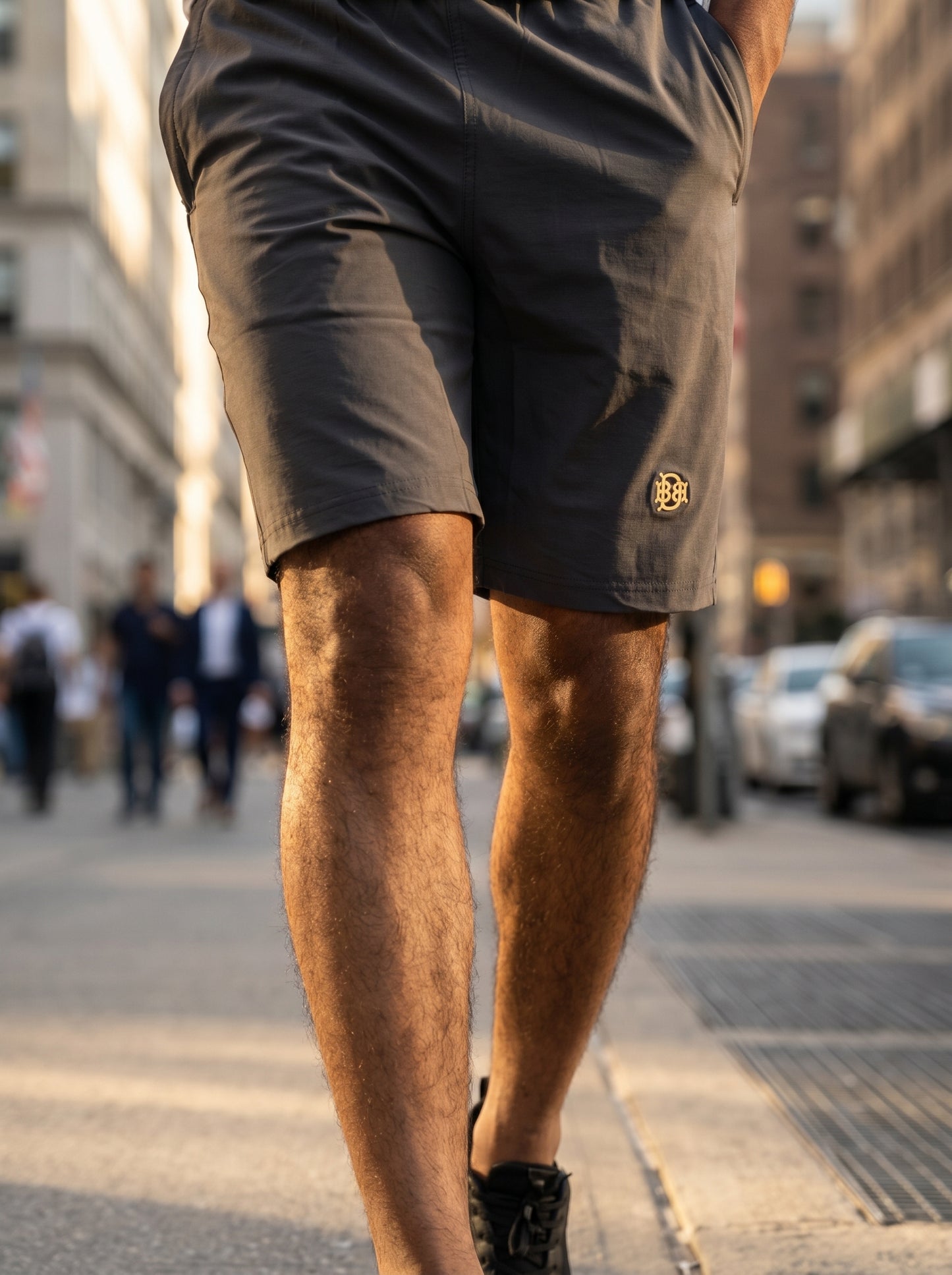 Dark grey tech shorts, back view with side logo patch near hem